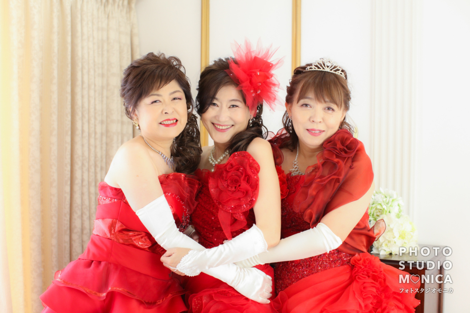 写真:お友達と赤いカラードレスで揃えて還暦記念写真撮影